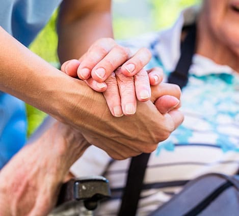Nurse consoling senior woman holding her hand