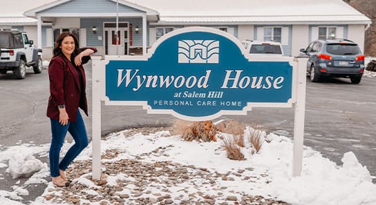 Brittany Wrye leanding next to Wynwood House Sign