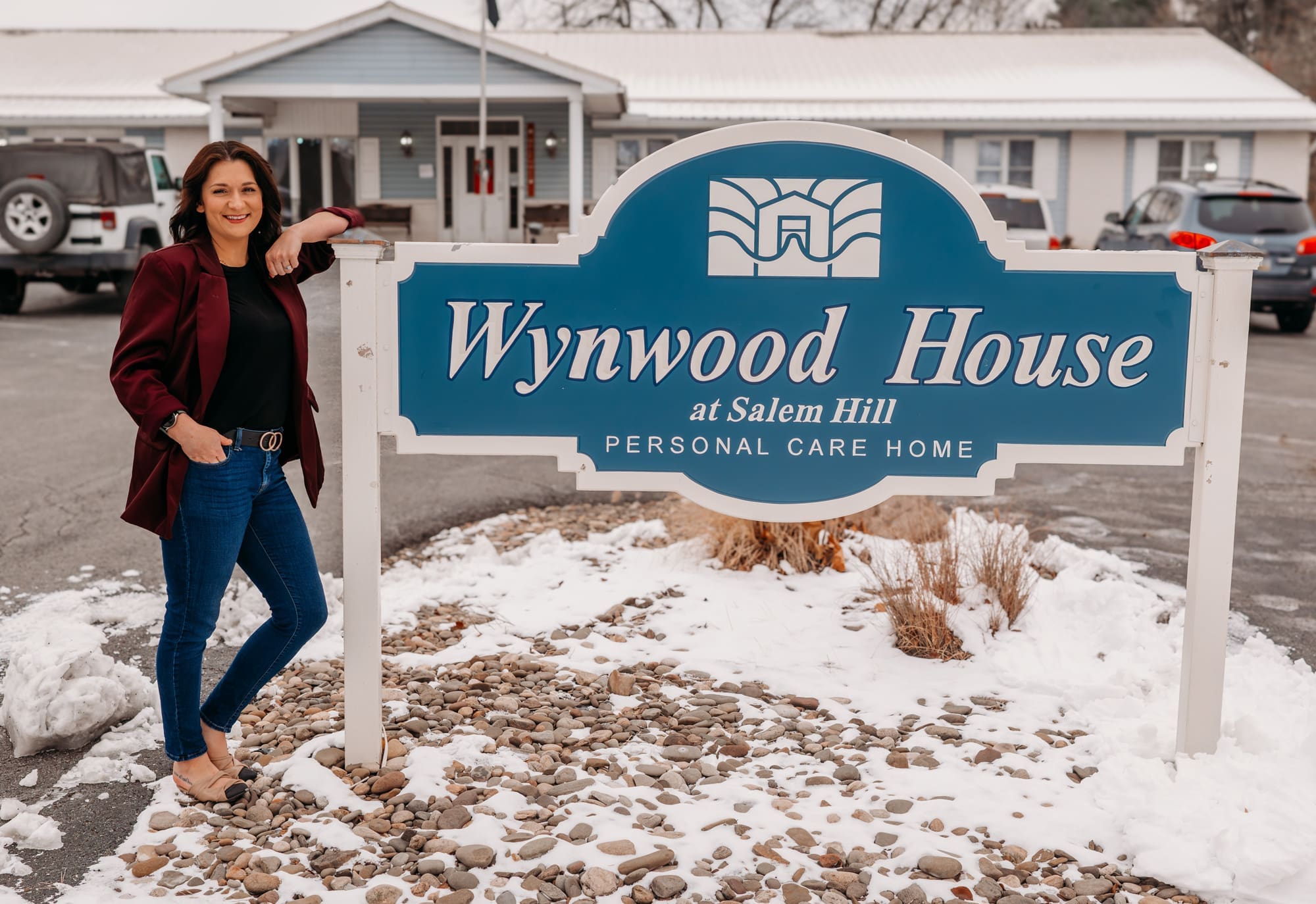 Brittany Wrye leanding next to Wynwood House Sign