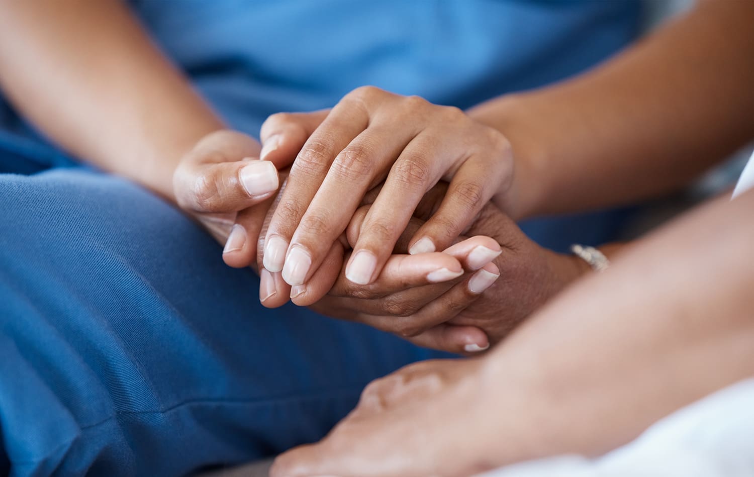 People holding hands in a comforting way.